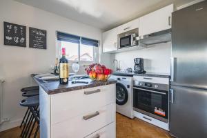 a kitchen with a refrigerator and a counter with a bowl of fruit at Le SAPHIR - 20min from Paris & CDG Airport - 2 bathrooms - 2 Desks in Drancy