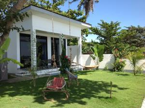 a house with a swing in the yard at BambooBeachVilla1 AC New OCEANFRONT POOL sunsetview garden kitchen SATELLITE STARLINK WI-FI in Dimiao
