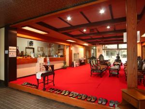 大町市にあるゲストルーム　ふる里村工芸館の赤いカーペットと椅子が敷かれた部屋