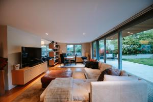 a living room with a couch and a television at Lakeside Road - Sleeps 8 - Lake Views - Lake Front in Wanaka