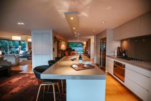 a kitchen with a island with a bottle of wine on it at Lakeside Road - Sleeps 8 - Lake Views - Lake Front in Wanaka