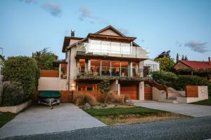 a large house with a balcony on the side of it at Lakeside Road - Sleeps 8 - Lake Views - Lake Front in Wanaka