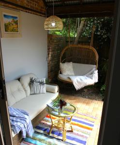 a porch with a couch and a table and a swing at Byron Marvell in Byron Bay
