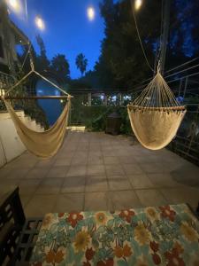 2 hamacas colgadas en un patio por la noche en Magnolias Jardin & Boutique Suites, en León