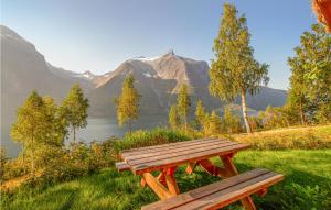 a wooden bench sitting in the grass with a view of a mountain at Cozy Home In Eikesdal With House Sea View in Øverås