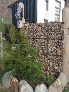 Una pared de piedra con un cartel encima. en EL Carpintero en El Chaltén