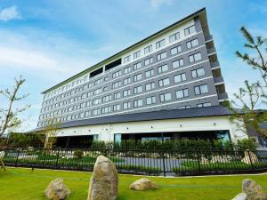 un gran edificio con rocas delante de él en Grandvrio Hotel Beppuwan Wakura - ROUTE INN HOTELS -, en Beppu