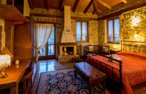 a bedroom with a bed and a fireplace at Pigi Tarlampa Hotel in Ano Trikala