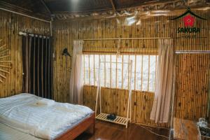 um quarto com uma cama e uma janela com em SAKURA House - Vườn Đào em Mộc Châu