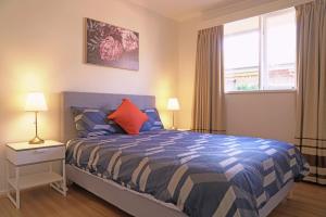 1 dormitorio con 1 cama, 2 lámparas y ventana en Family home in Prime location Melbourne, en Fern Tree Gully