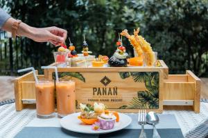 una mesa de madera con un buffet de zumo de naranja en Panan Krabi Resort - SHA Extra Plus en Ao Nang Beach