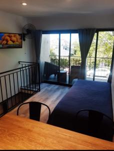 a bedroom with a bed and a table and a balcony at PH playa Grande in Mar del Plata