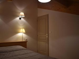 a bedroom with a bed and two lights on the wall at Appartement Font-Romeu-Odeillo-Via, 3 pièces, 6 personnes - FR-1-580-77 in Font-Romeu-Odeillo-Via