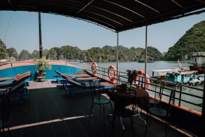 a boat on the water with tables and chairs at Cat Ba Bay Cruises in Cat Ba