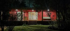 czerwony dom z białymi drzwiami w nocy w obiekcie OMA CHILL HOUSE IGUAZU w mieście Puerto Iguazú
