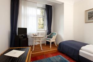Habitación de hotel con cama, mesa y ventana en Parkhotel Atlantic en Heidelberg