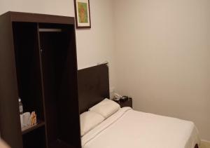 a small bedroom with a bed and a mirror at Hotel Desaru Penawar in Desaru