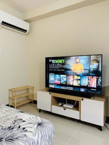 Una sala de estar con un televisor de pantalla plana grande. en Angel's Nest, en Lo-oc