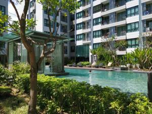 a swimming pool in front of a building at 4 Floor - Centrio Condominium near Shopping Malls and Andamanda Water Park in Phuket Town