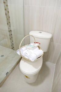 a bathroom with a toilet with a basket of towels at Habitacion Con Balcón Vista Mar Playa & Piscina in Playas