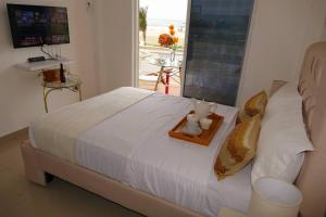 a bed with a tray with a teddy bear on it at Habitacion Con Balcón Vista Mar Playa & Piscina in Playas +46 photos