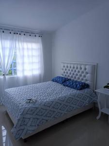 a bed in a white room with a window at Apartamento Roldanillo pueblo mágico in Roldanillo