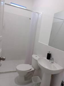 biała łazienka z toaletą i umywalką w obiekcie Apartamento Roldanillo pueblo mágico w mieście Roldanillo