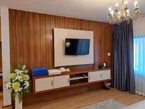 uma sala de estar com televisão numa parede de madeira em The Chic Pool Villa em Nai Yang Beach