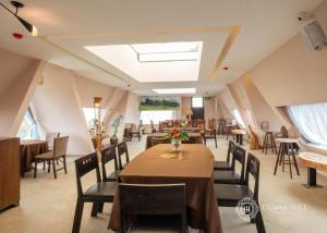 uma sala de jantar com mesas e cadeiras e uma clarabóia em Guava Hill Boutique Hotel em Da Lat