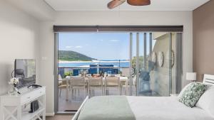 a bedroom with a bed and a view of the ocean at Solaris in Fingal Bay