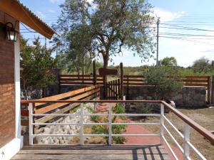 porche con barandilla de madera y valla en Los olivos en Capilla del Monte