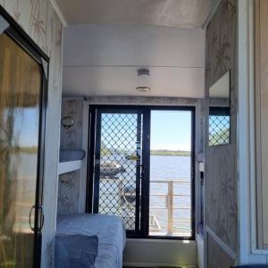 a bedroom with a window with a view of the water at The one & only Houseboat Hire on Maroochy River in Maroochydore