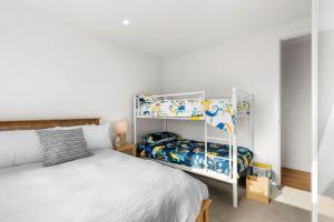um quarto com uma cama e um beliche em Just built luxury Townhouse em Torquay