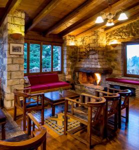 a living room with a couch and a stone fireplace at Pigi Tarlampa Hotel in Ano Trikala