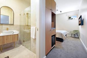 a bathroom with a shower and a sink and a mirror at The Tanunda Club Guest Suites in Tanunda +34 photos