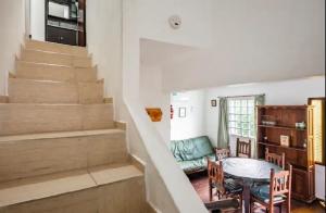 a living room with stairs and a table and chairs at Dúplex complejo - Centro Villa Gesell - 5 huéspedes in Villa Gesell