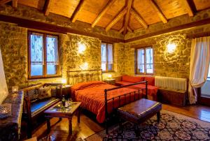 a bedroom with a bed and a couch at Pigi Tarlampa Hotel in Ano Trikala