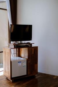 uma televisão de ecrã plano num suporte de madeira num quarto em Bundhaya Villas em Koh Lipe