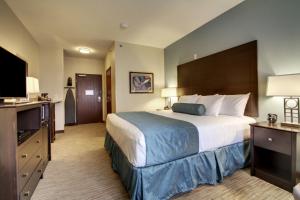 a hotel room with a large bed and a flat screen tv at Cobblestone Inn & Suites - Fort Dodge in Fort Dodge