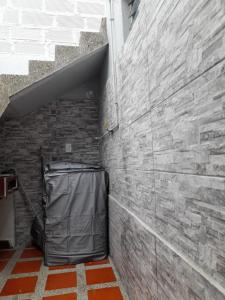 a room with a brick wall with a trash can at Amoblado centro de la Moda in Itagüí