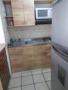 a small kitchen with a sink and a microwave at Amoblado centro de la Moda in Itagüí