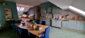 cocina con mesa de madera y sillas azules en Apartament w Komornikach, en Komorniki