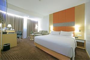a hotel room with a large bed and a desk at All Sedayu Hotel Kelapa Gading in Jakarta
