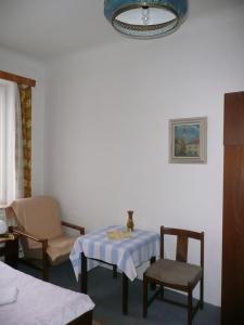 プラハにあるApartment Trojskaのテーブルと椅子、シャンデリアが備わる客室です。