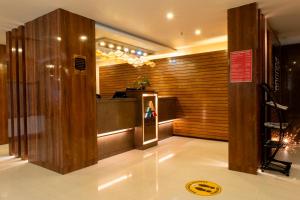 a lobby with a woman standing at the counter at Hotel Prism - A Boutique Hotel in Jorhāt