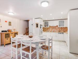 a white kitchen with a white table and chairs at Maison Betpouey, 5 pièces, 8 personnes - FR-1-402-83 in Betpouey
