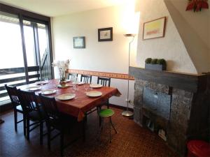 a dining room with a table and a fireplace at Appartement Saint-Lary-Soulan, 3 pièces, 9 personnes - FR-1-457-157 in Saint-Lary-Soulan