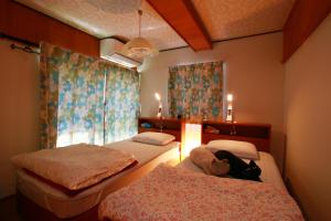 a bedroom with two beds and a teddy bear on the bed at Kitsunenotebukuro 