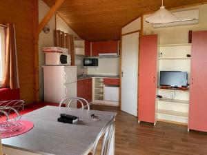 a room with a kitchen with a table and a refrigerator at Chalet Agde, 3 pièces, 6 personnes - FR-1-607-59 in Agde