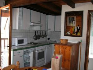 cocina con armarios blancos y microondas en Chalet Les Angles, 4 pièces, 6 personnes - FR-1-295-145, en Les Angles